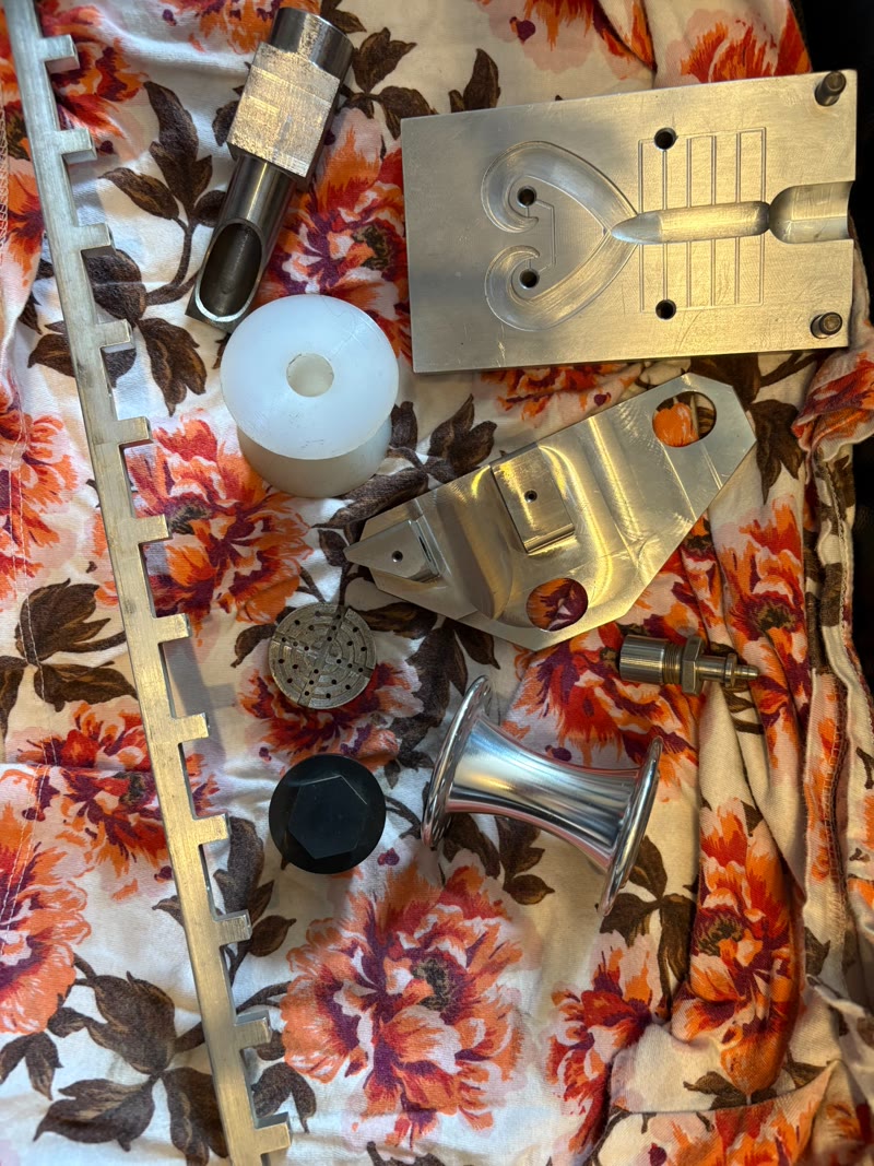 Variety of precision machined parts including CNC milled plates, plastic components, and polished metal pieces by RPM Machining